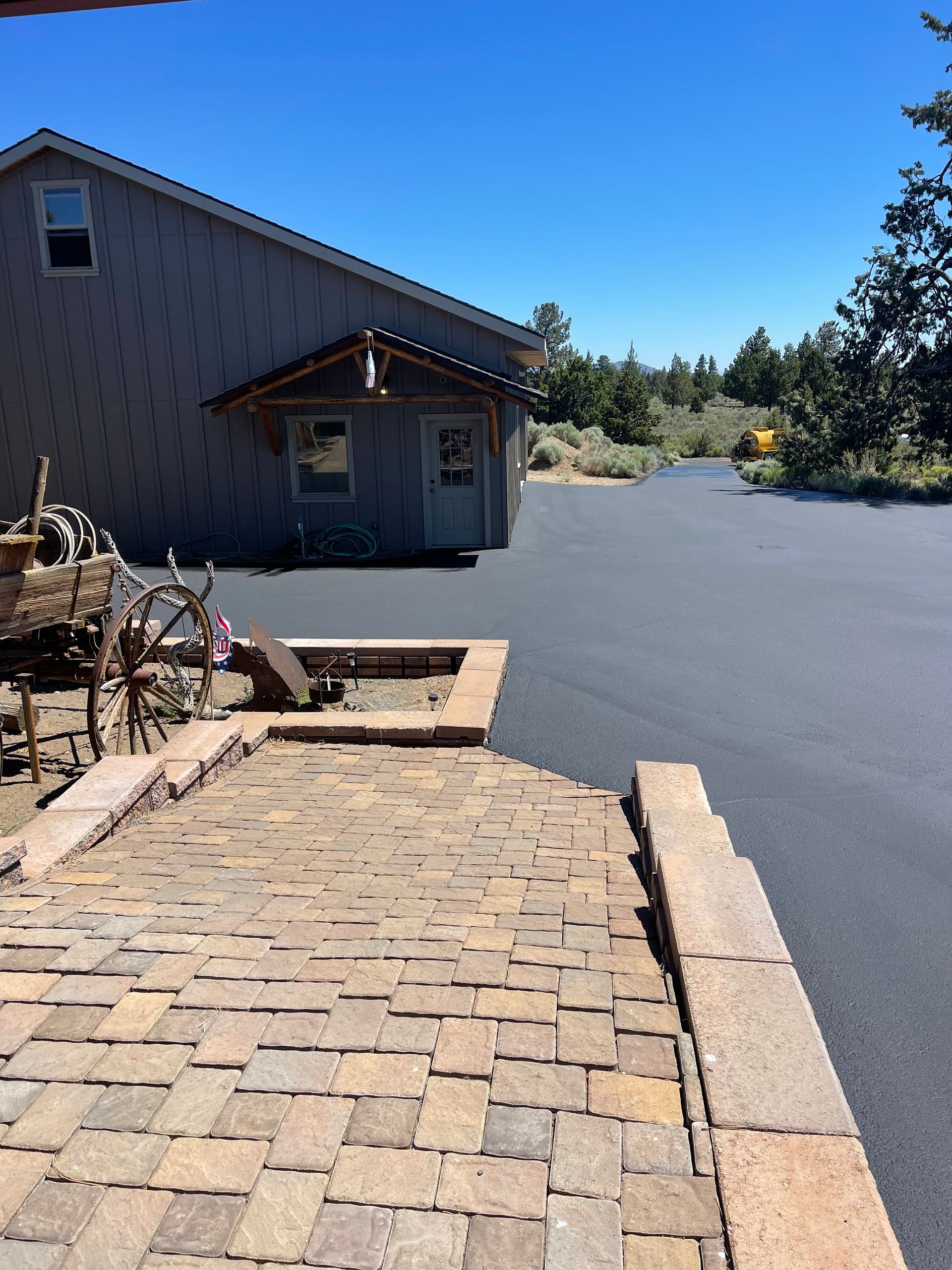 A house with a driveway and a brick walkway leading to it