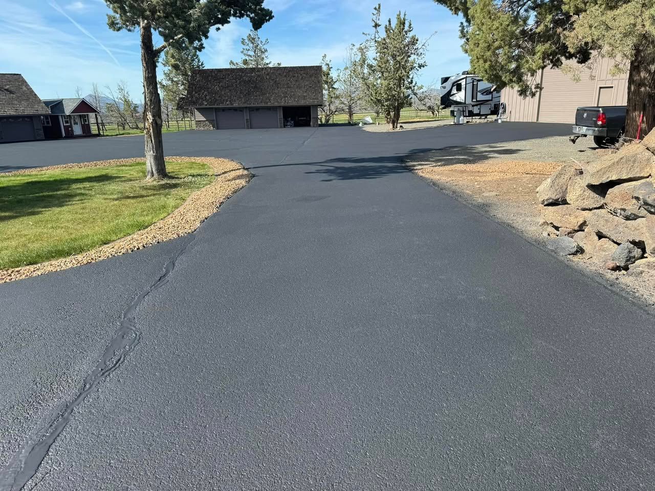 A black truck is parked on the side of a road next to a house.