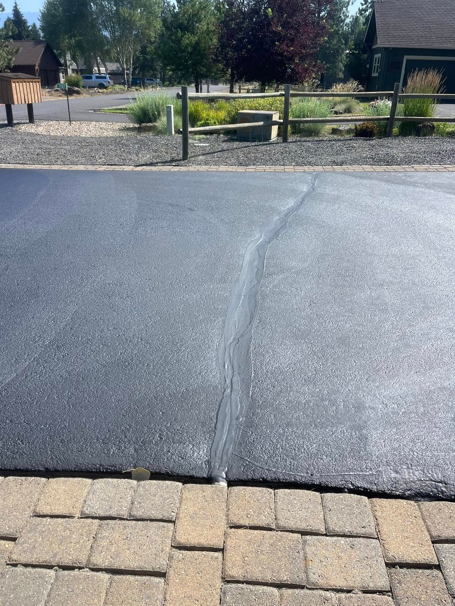 A piece of asphalt is sitting on top of a brick driveway.