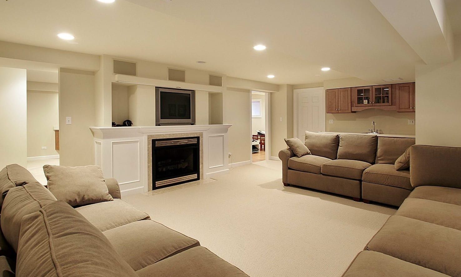 A living room with a couch , fireplace and television.