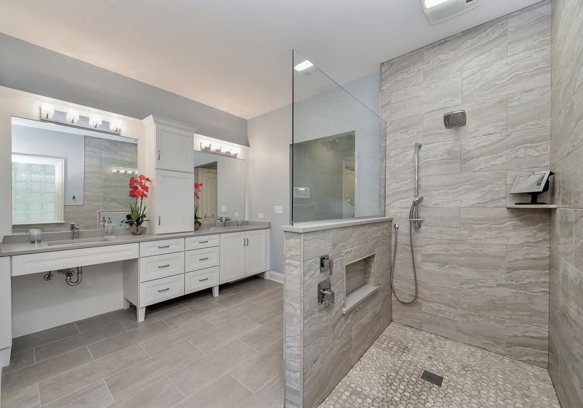 A bathroom with two sinks and a walk in shower.