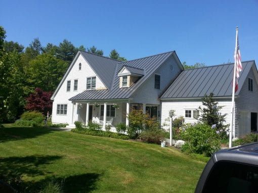 A large white house with a gray metal roof