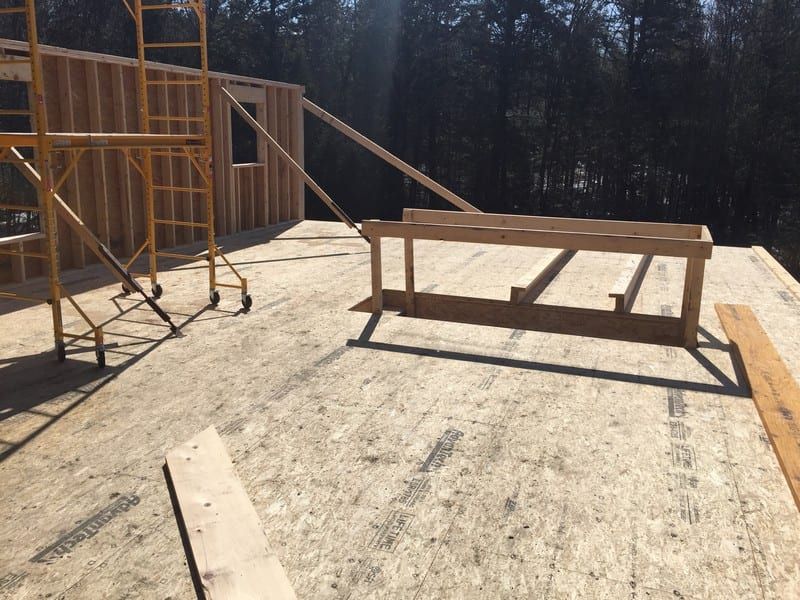 A wooden table is sitting on top of a wooden floor next to a scaffolding.