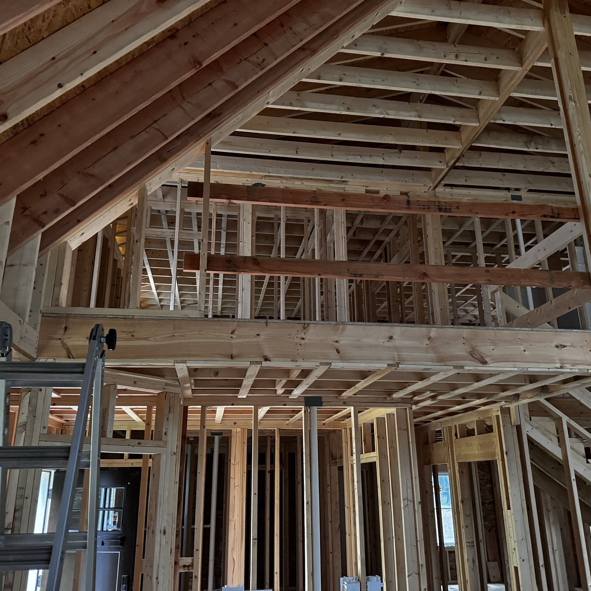 The inside of a house under construction with a ladder in the foreground