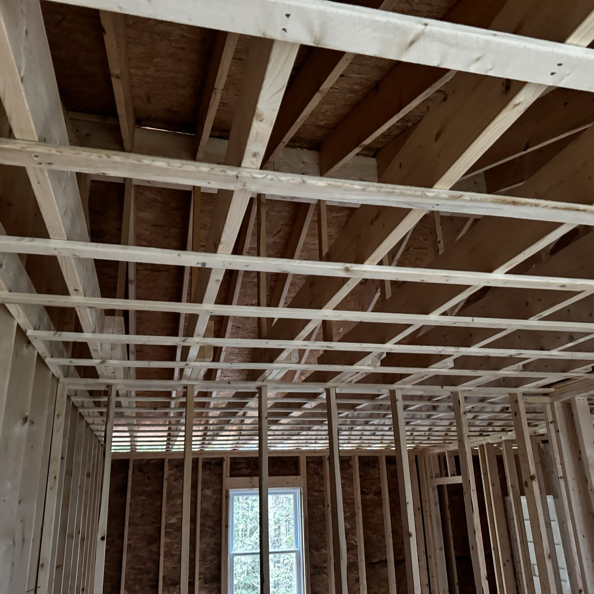 The ceiling of a building under construction with a window