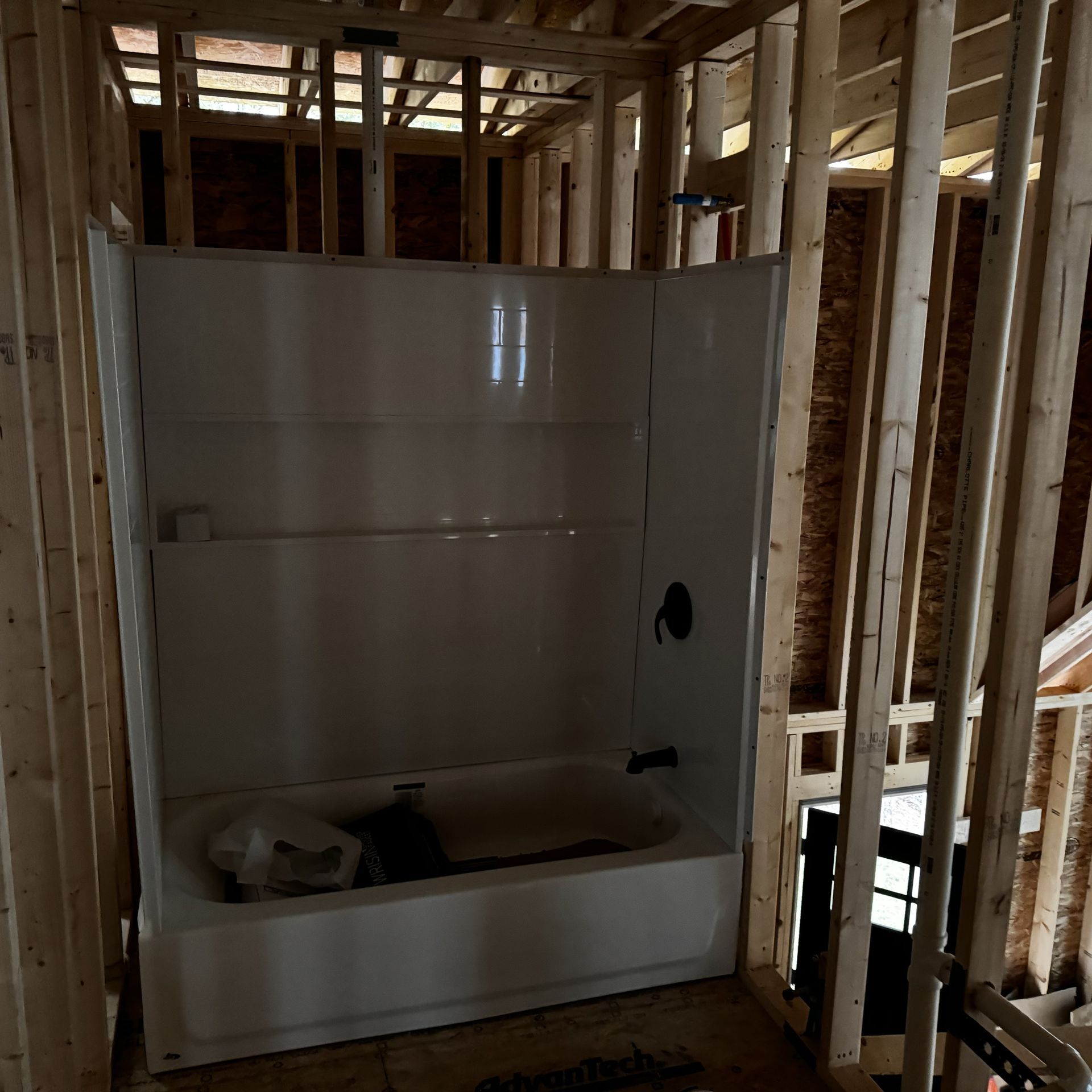 A bathtub is in the middle of a building under construction