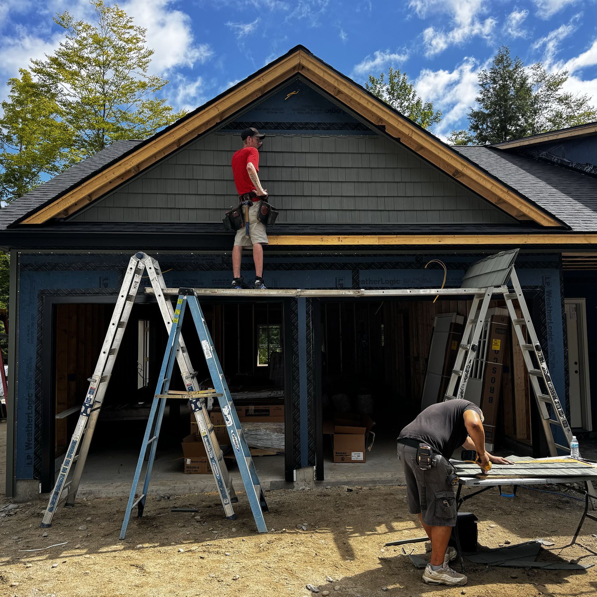 A man is standing on a ladder in front of a house