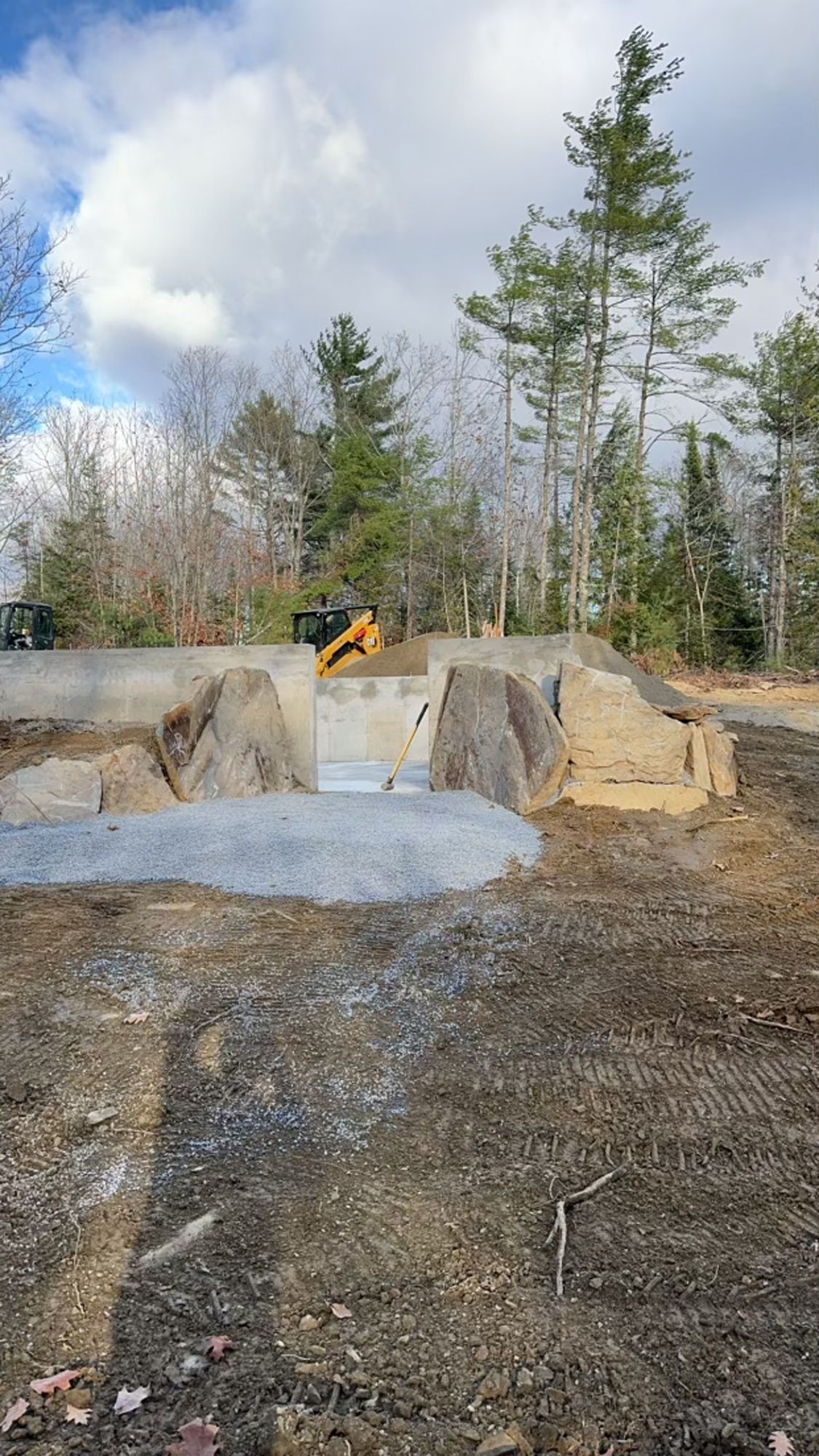 A large pile of rocks is sitting in the middle of a dirt field.