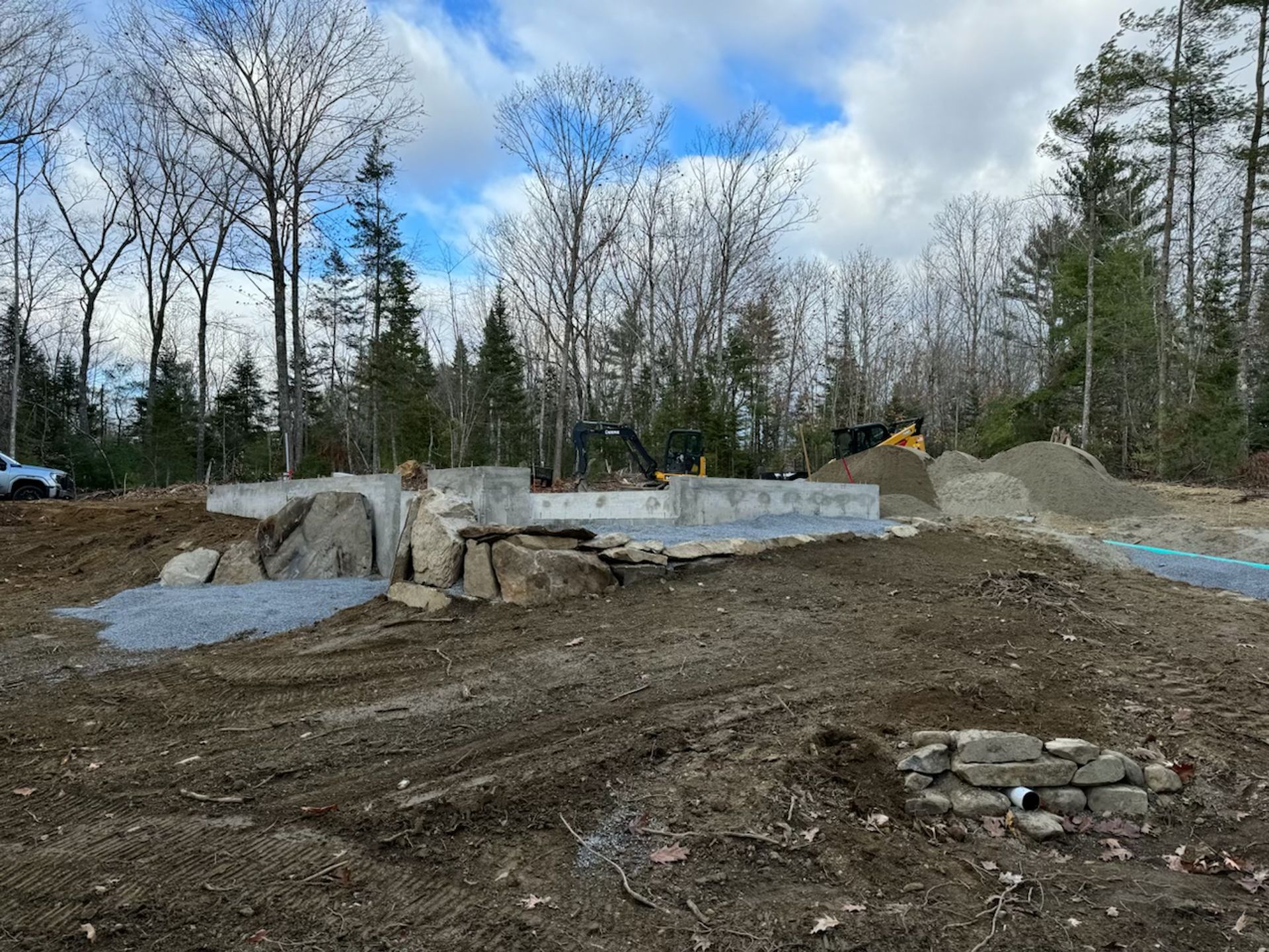 A construction site with a lot of dirt and trees in the background.