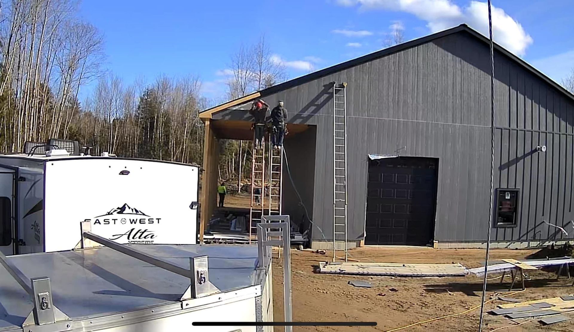 A man is standing on a ladder in front of a large building.