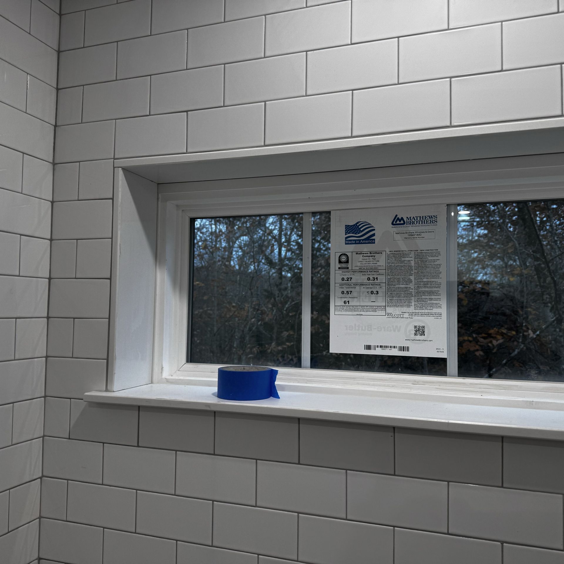A white brick wall with a window and a sign on it