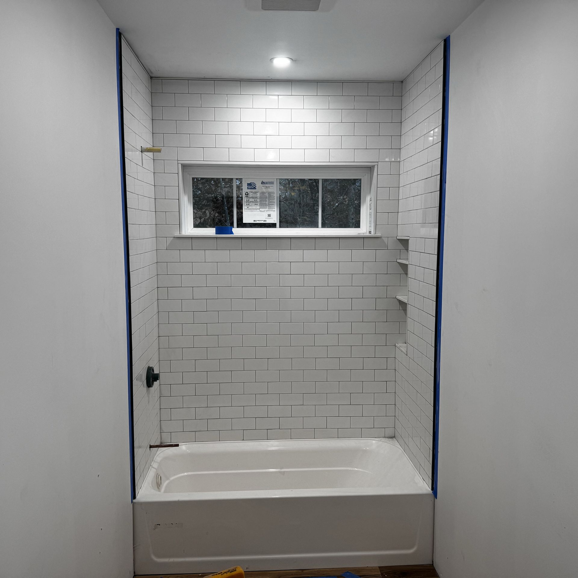 A bathroom with a bathtub and a window.