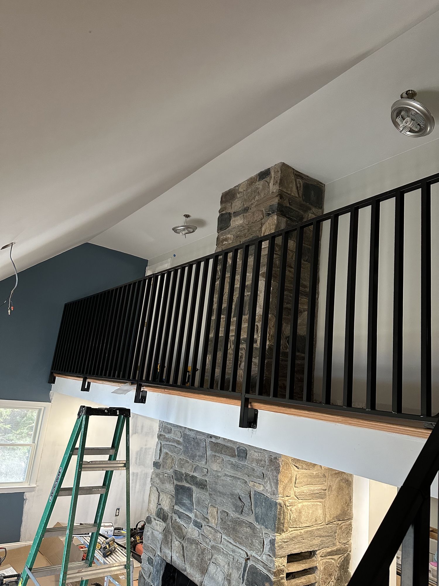 A ladder is sitting on a balcony next to a fireplace.