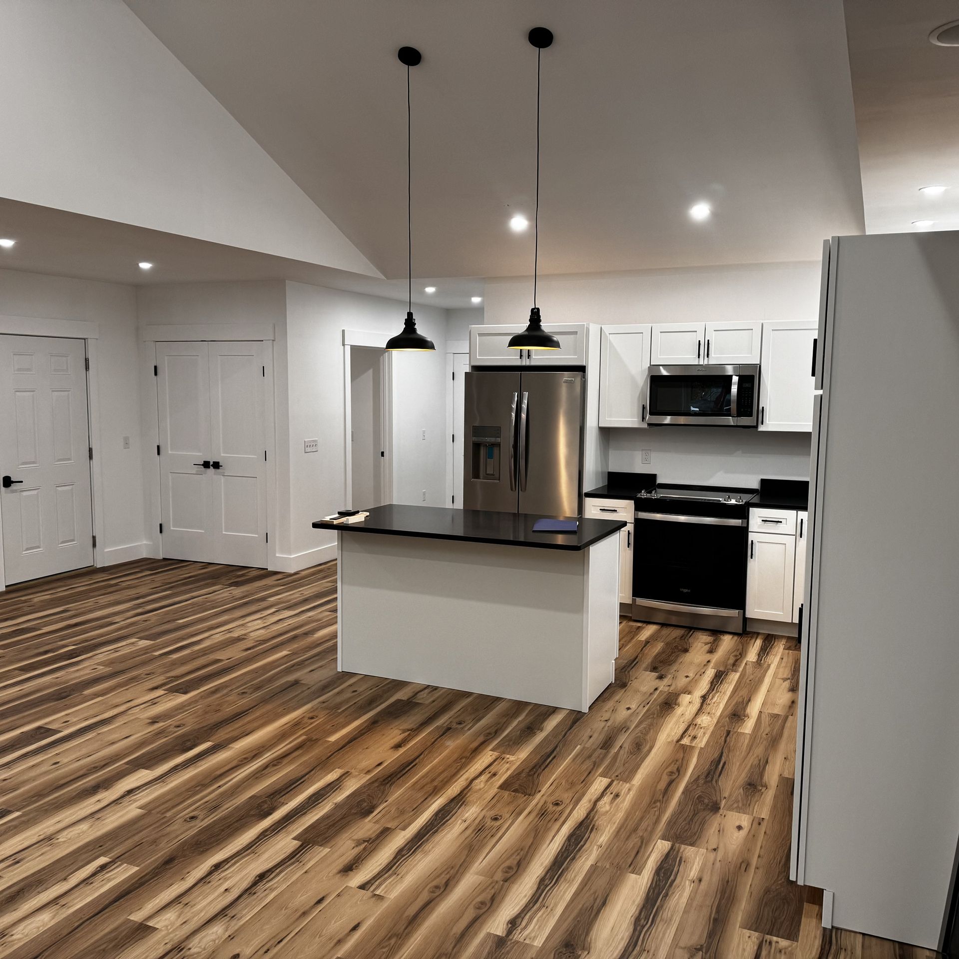 A kitchen with hardwood floors and stainless steel appliances