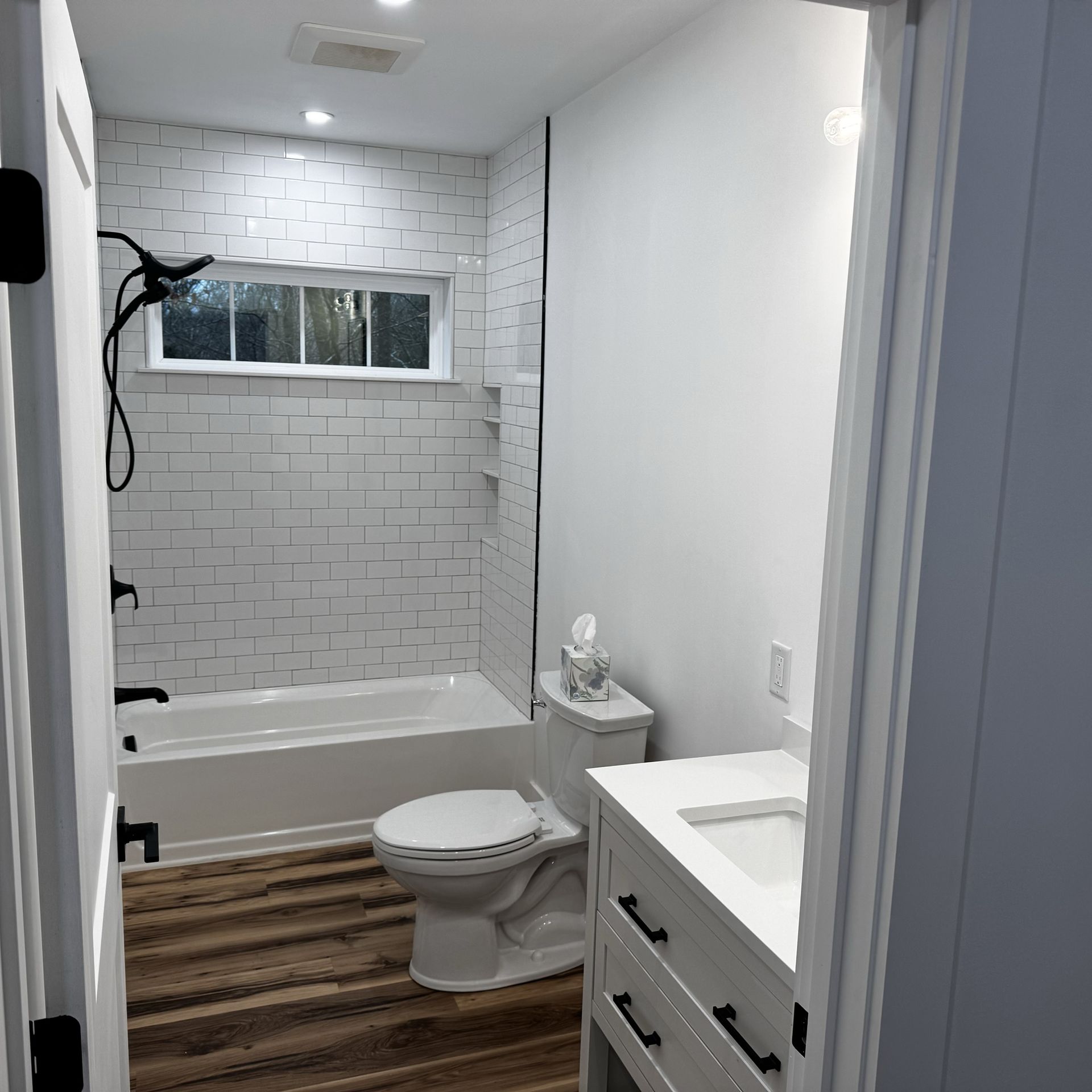 A bathroom with a toilet , sink , tub and shower.