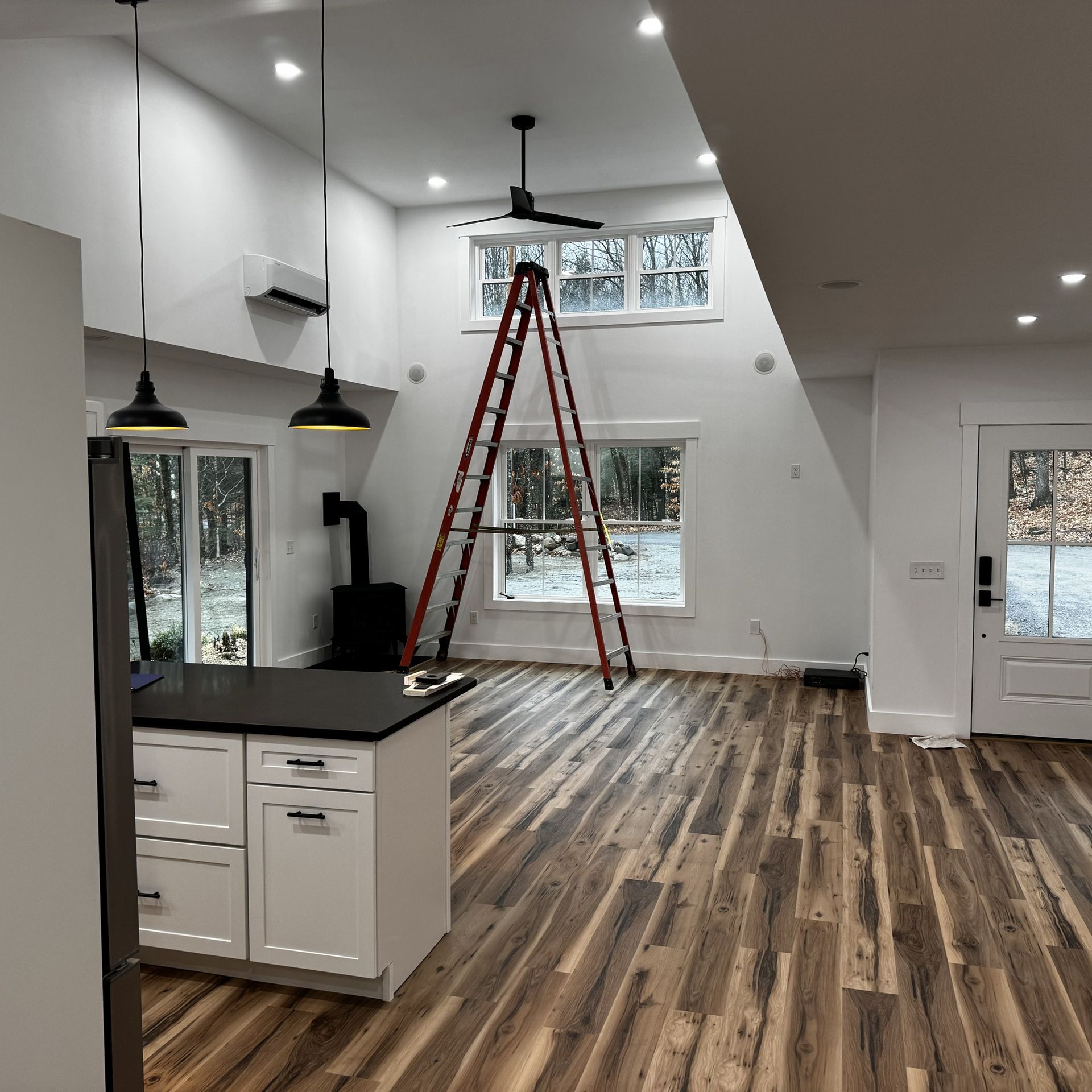 A kitchen with a ladder in the middle of the room