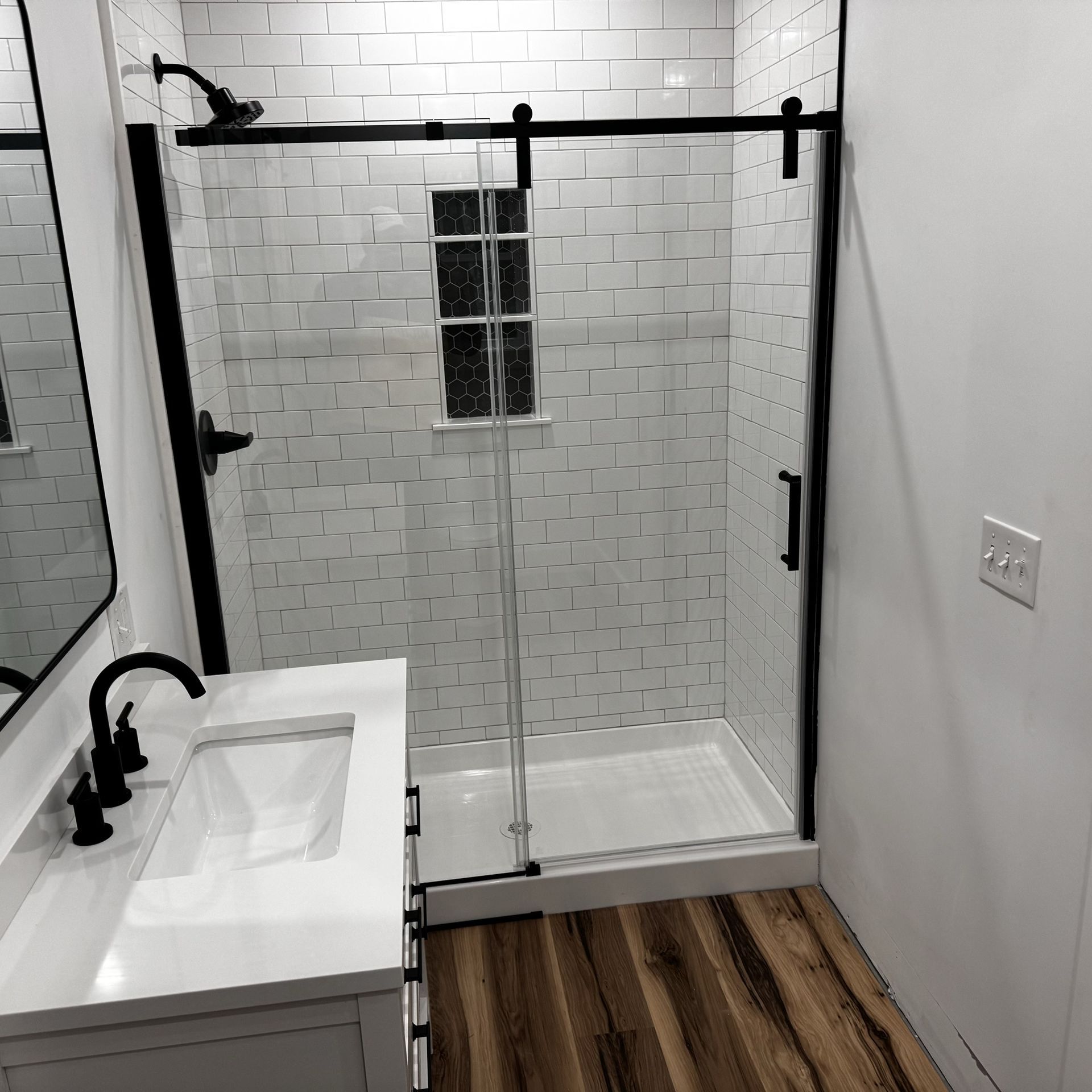 A bathroom with a sliding glass shower door and a sink.