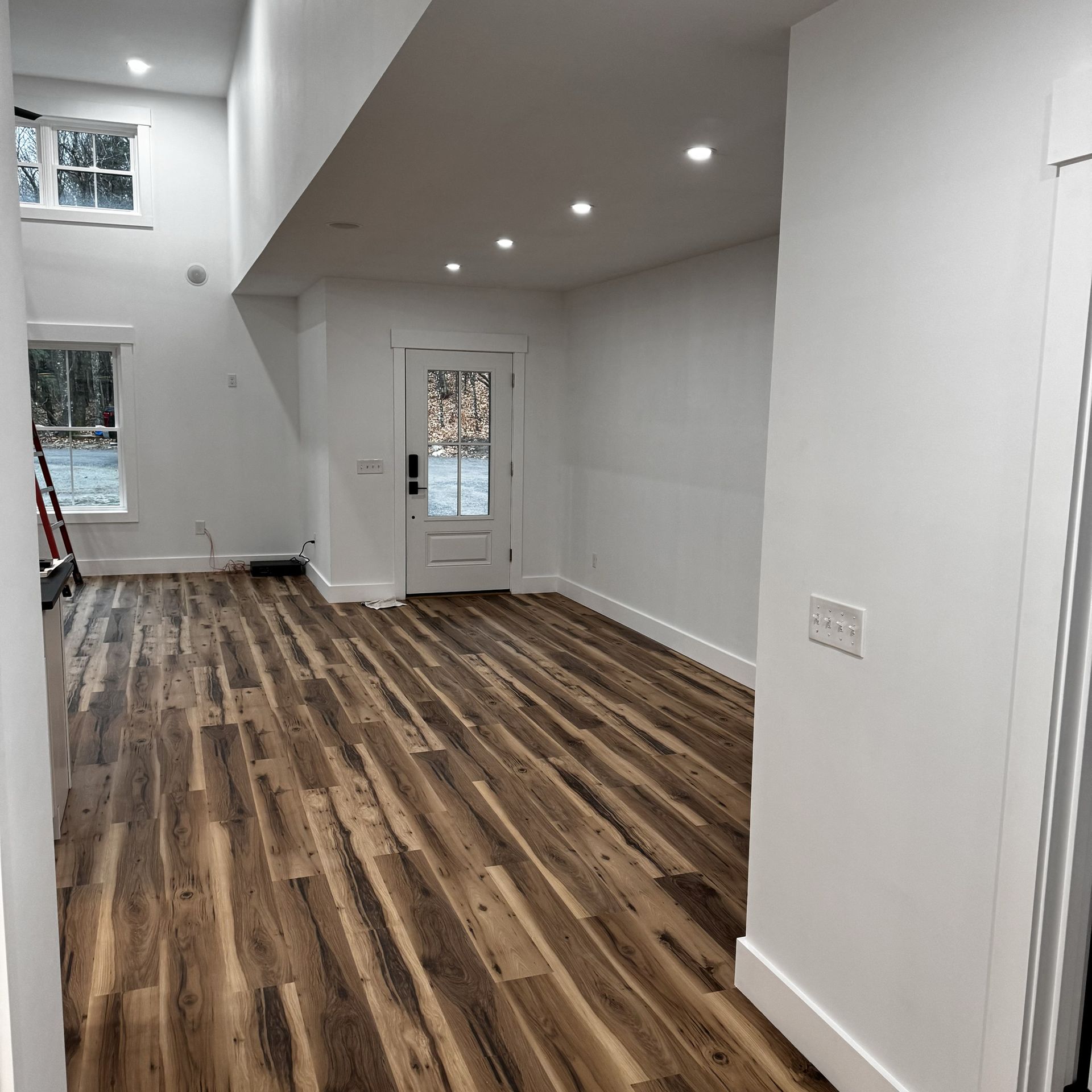 An empty room with hardwood floors and white walls
