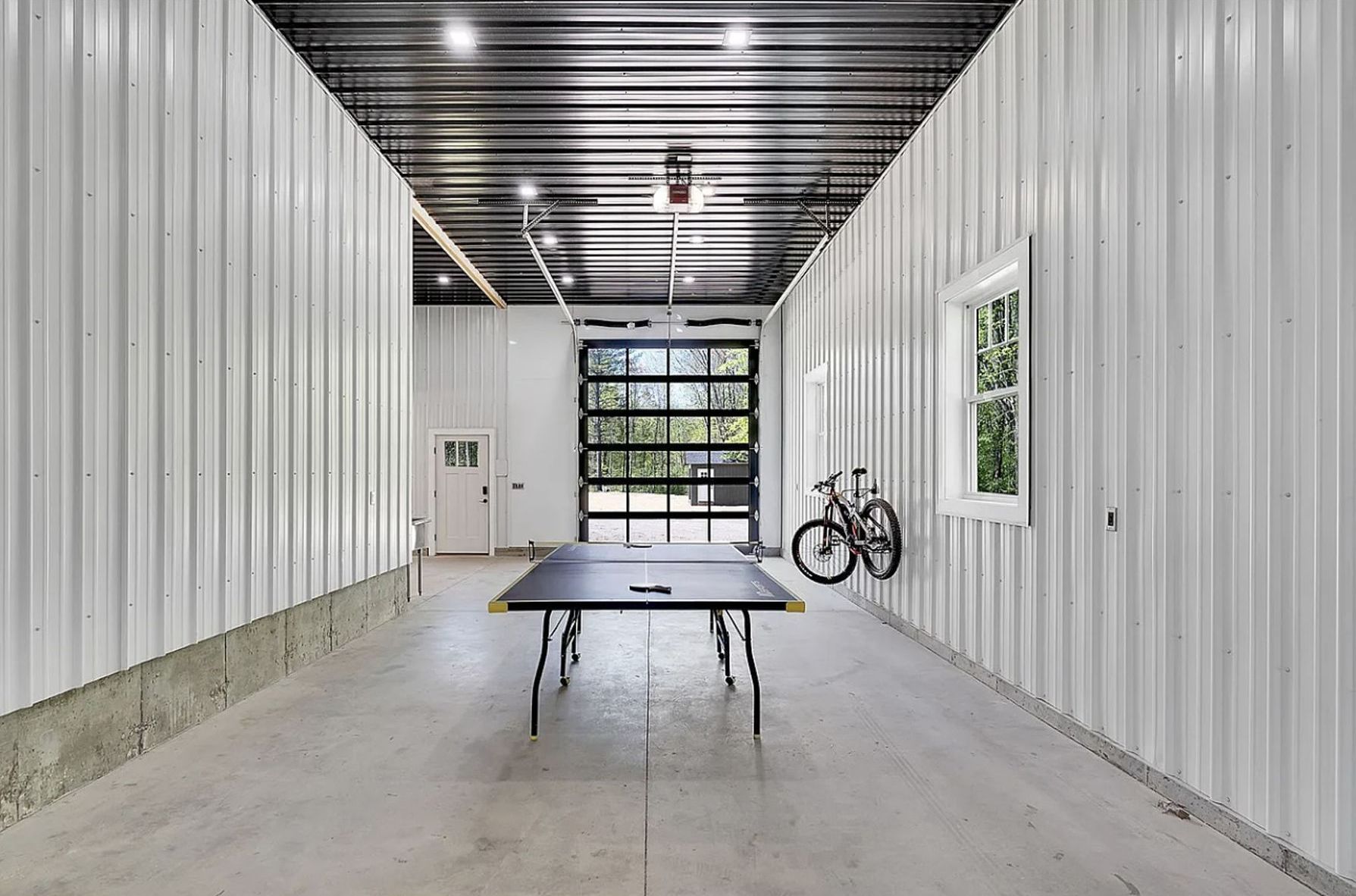 There is a ping pong table in the middle of the garage.
