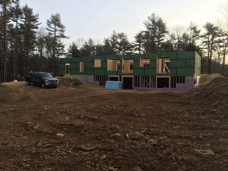 A truck is parked in front of a house under construction