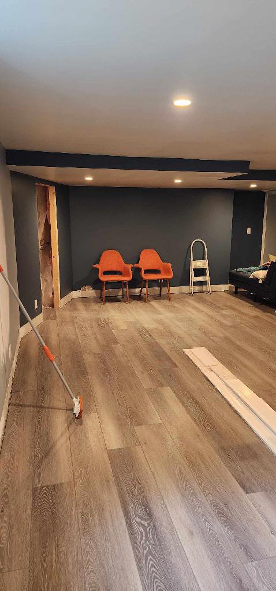A living room with hardwood floors and two chairs.