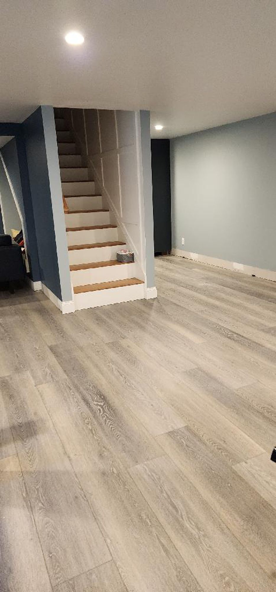 A basement with hardwood floors and stairs.