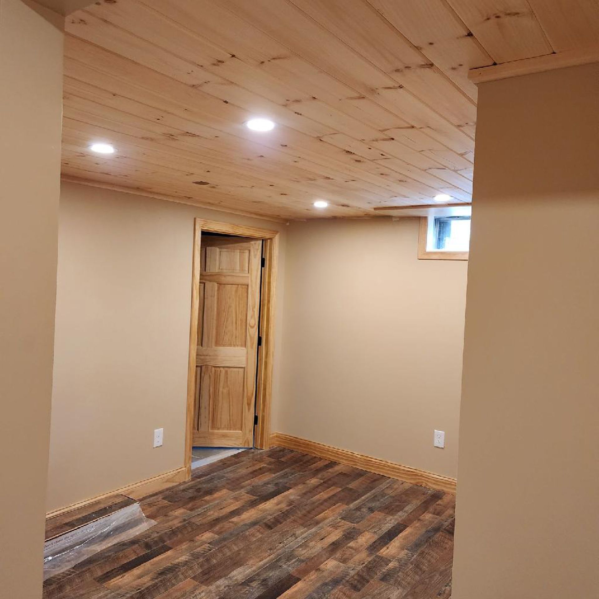 An empty room with wooden floors and a wooden ceiling.