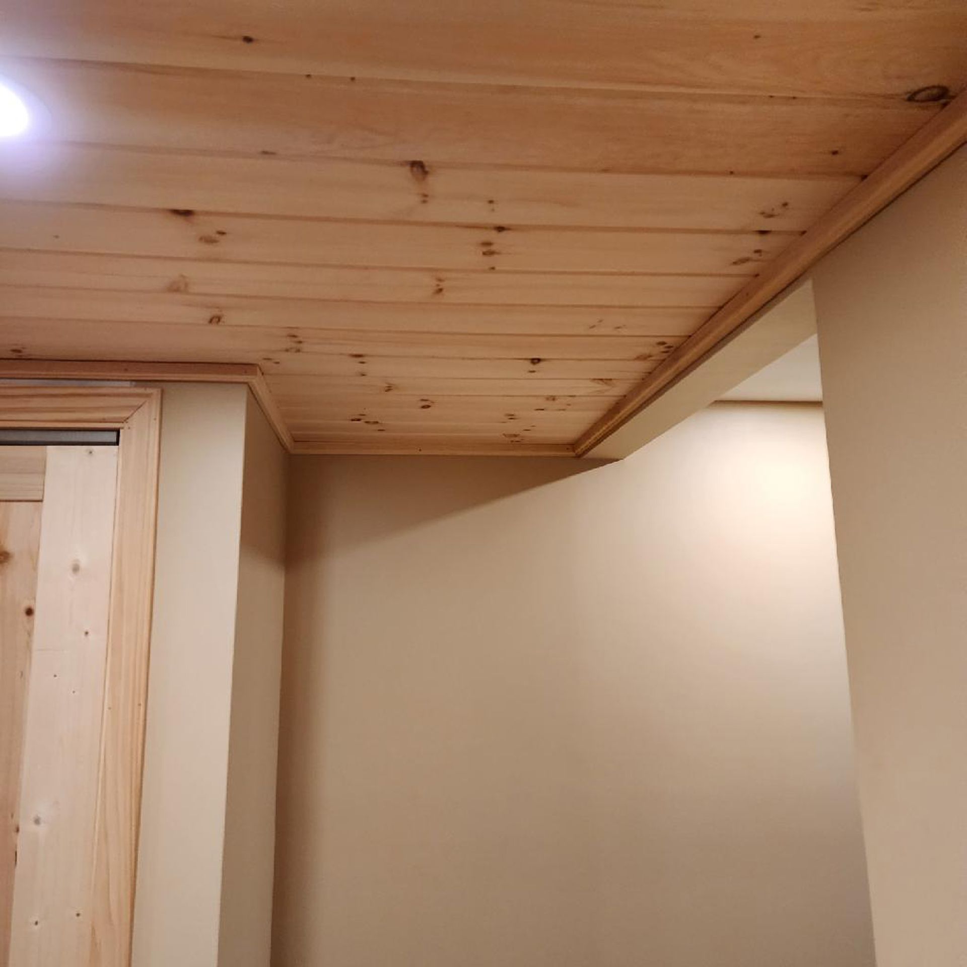 A room with a wooden ceiling and white walls.