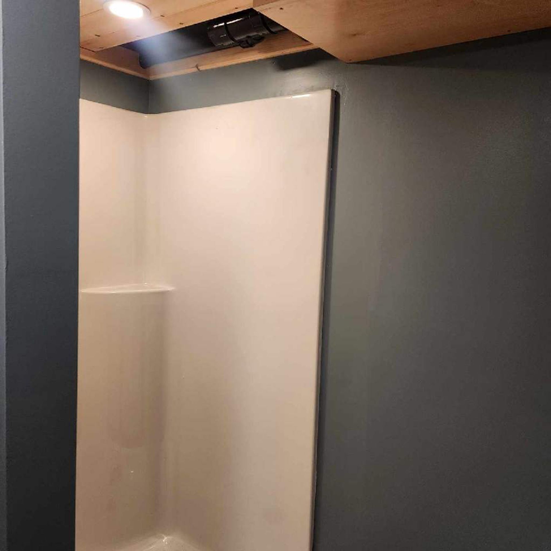 A bathroom with a shower and a ceiling fan.