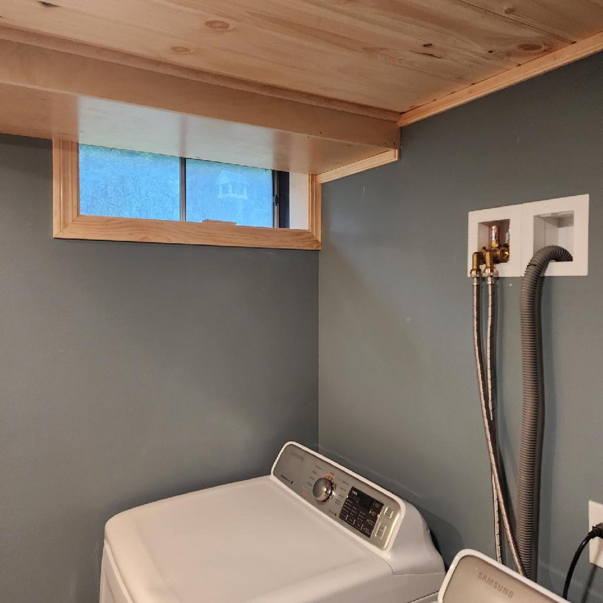 A laundry room with a washer and dryer and a window