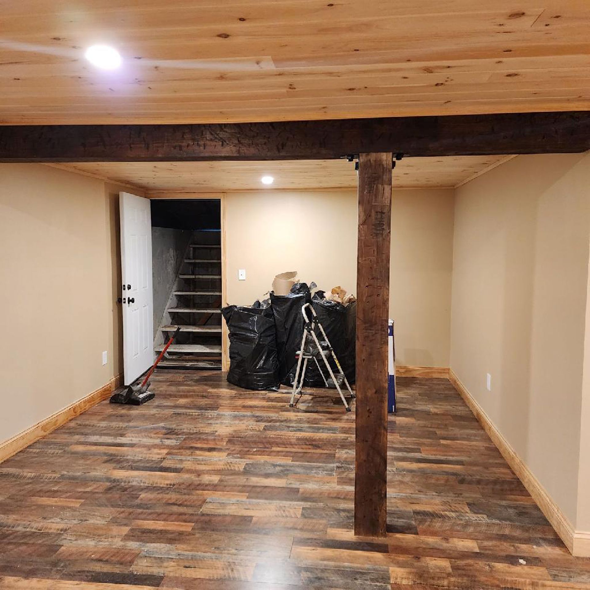 A basement with wooden floors and a wooden beam.