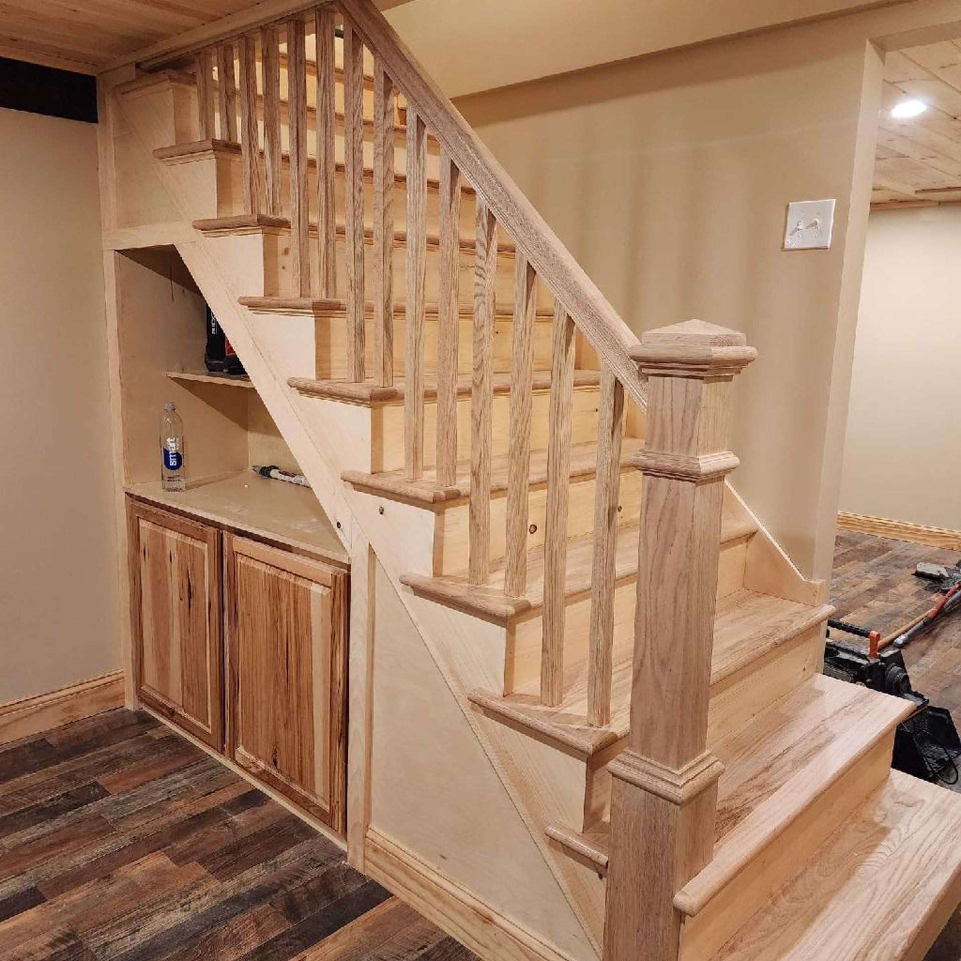 A wooden staircase in a basement with a wooden railing