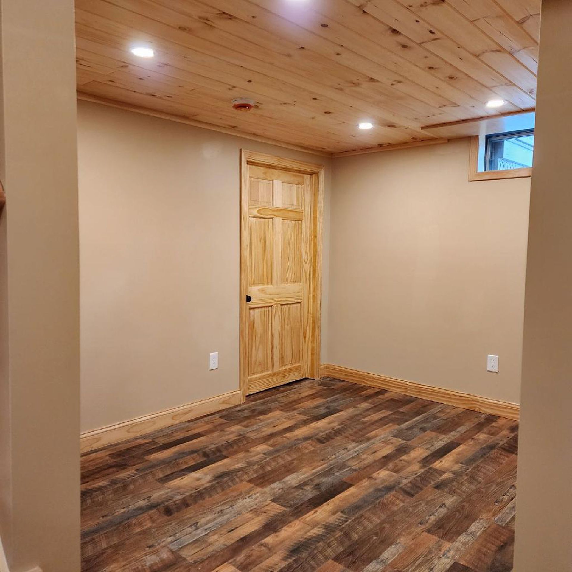 A room with a wooden floor and a wooden door.