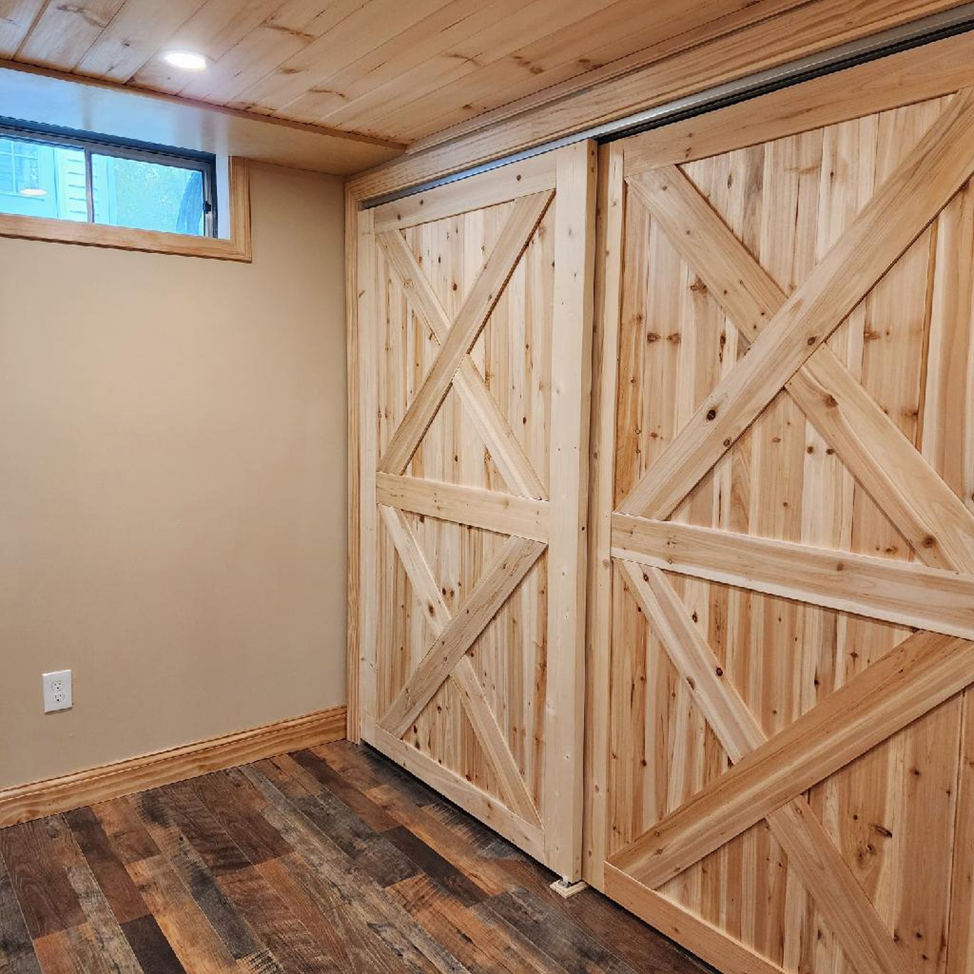 A room with a wooden floor and sliding barn doors