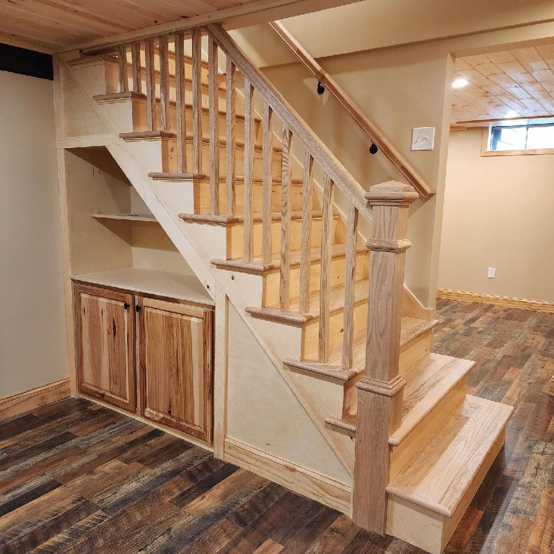 A wooden staircase in a basement with a wooden railing