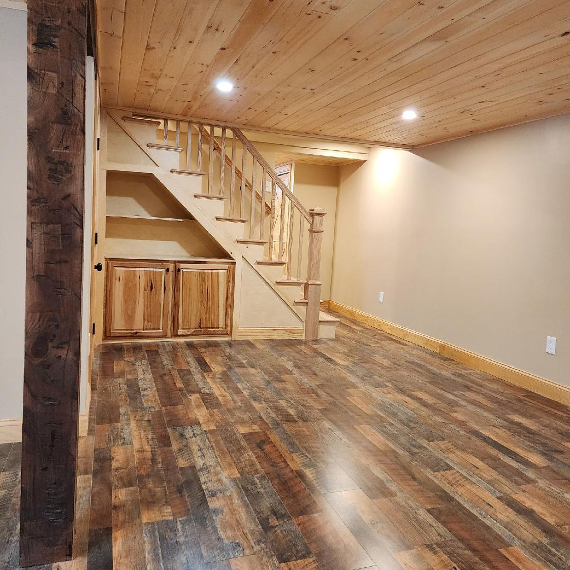 An empty room with wooden floors and stairs