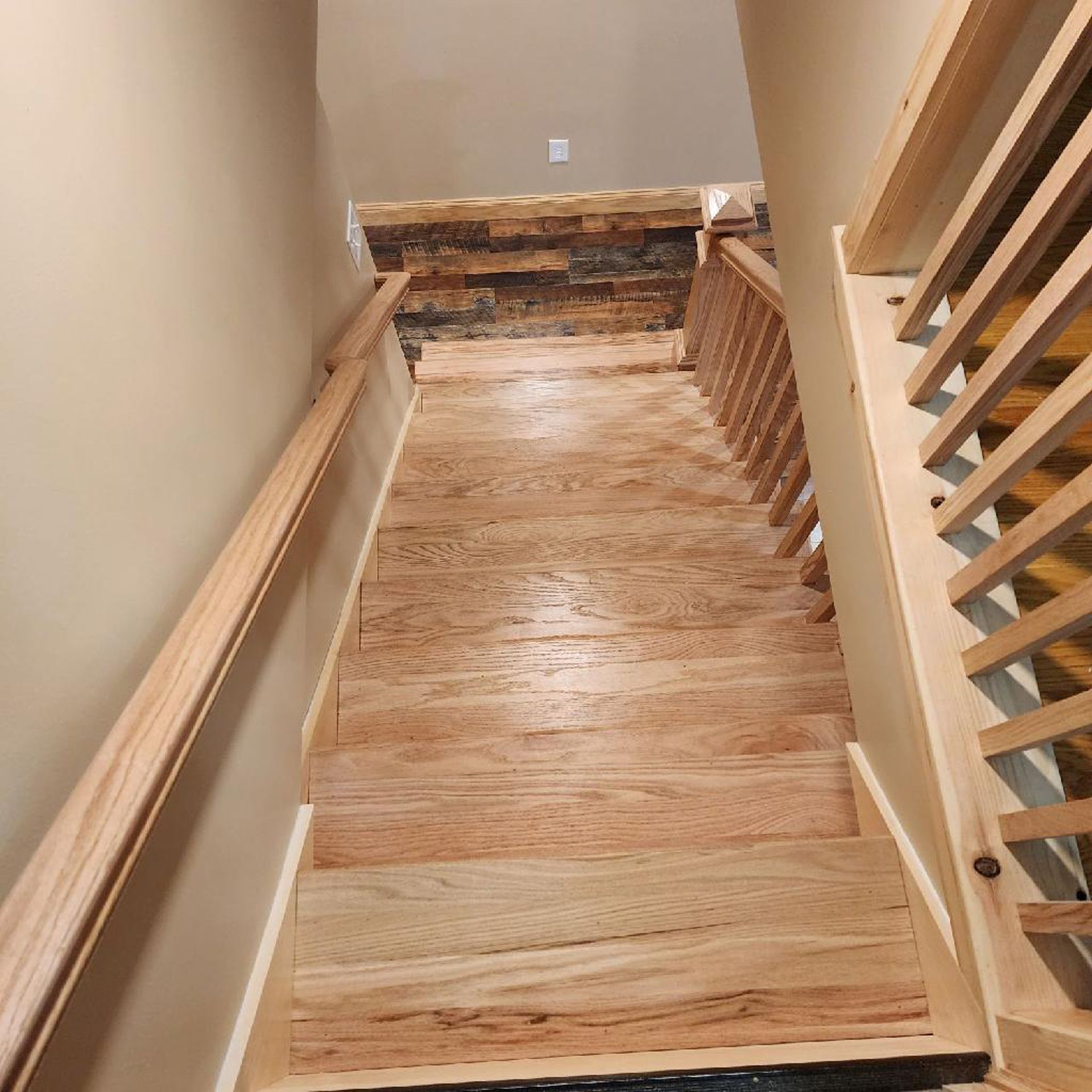 A wooden staircase with a railing and a stone wall