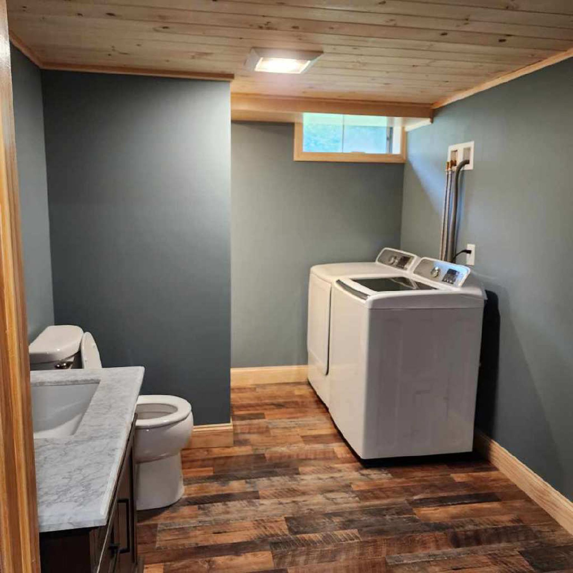A laundry room with a toilet , sink , and washer and dryer.