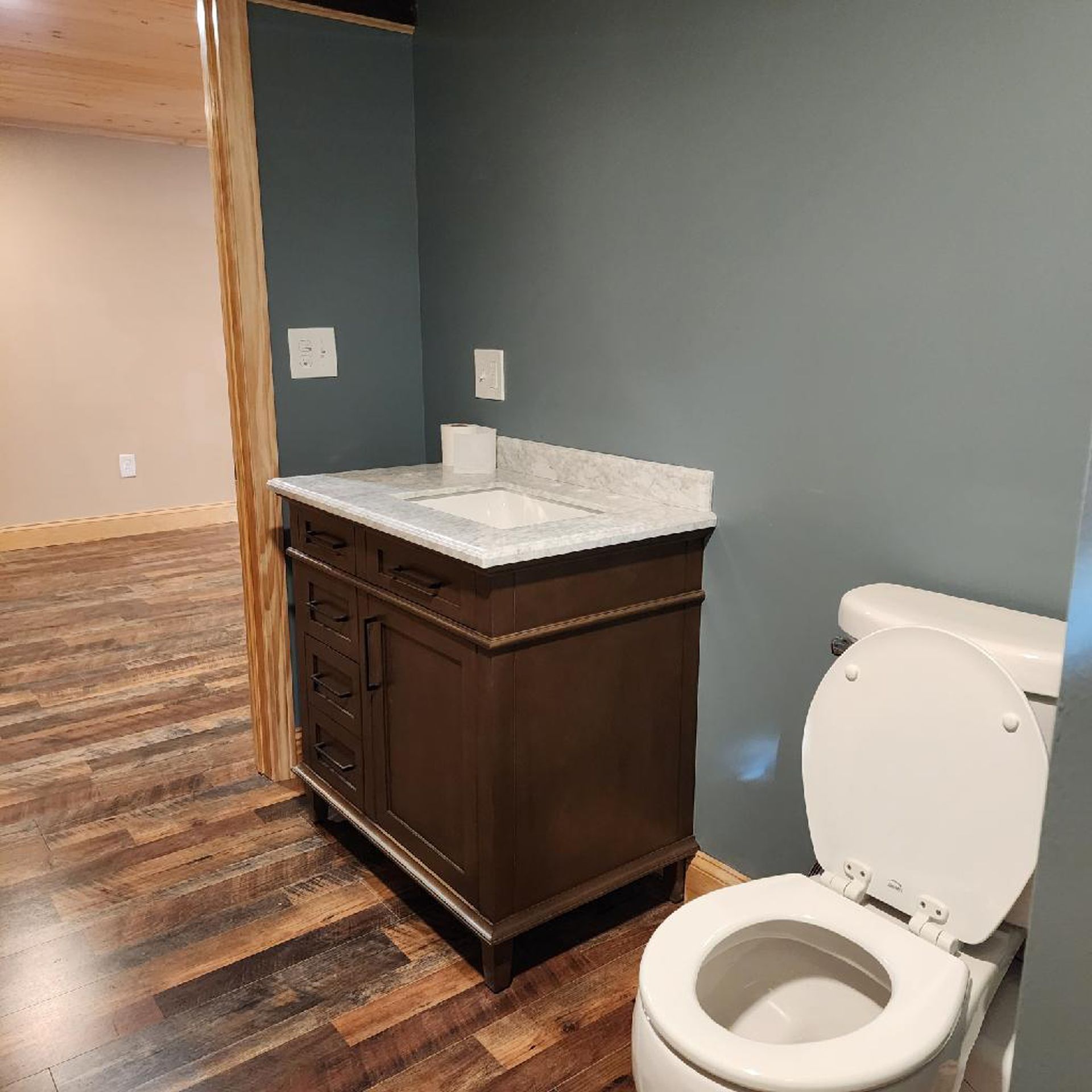 A bathroom with a toilet , sink and vanity.