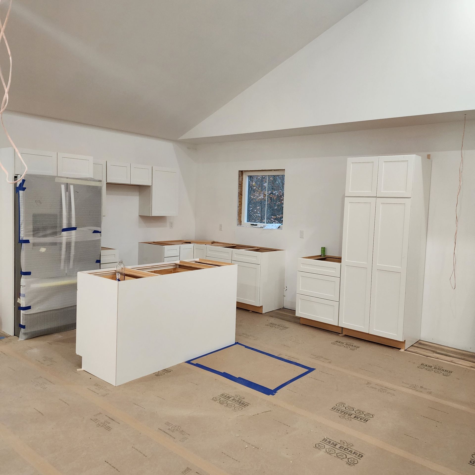 A kitchen under construction with a large island in the middle