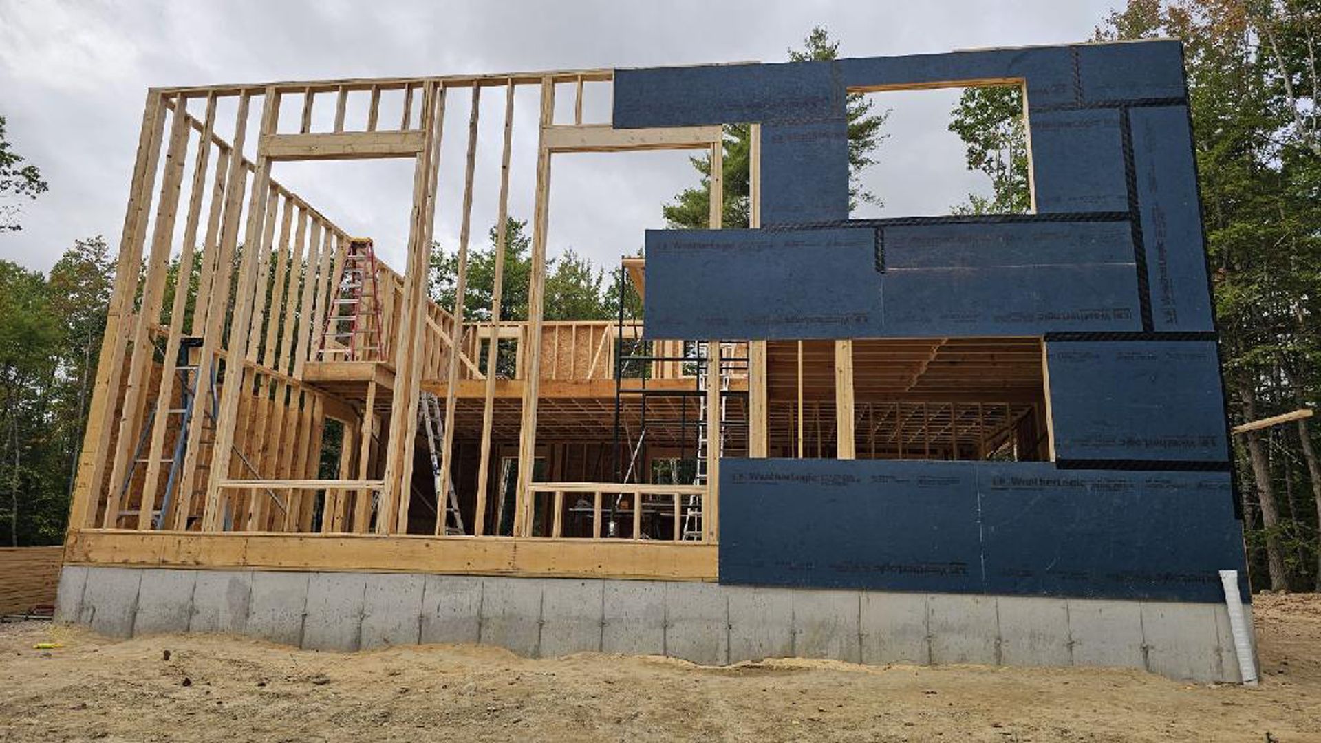 A house is being built in the middle of a dirt field.