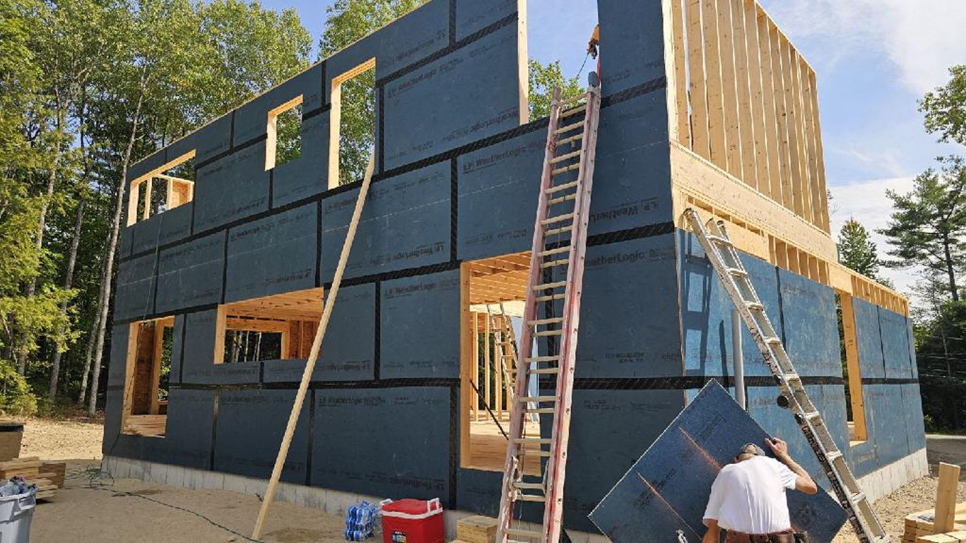 A man is standing in front of a building under construction.