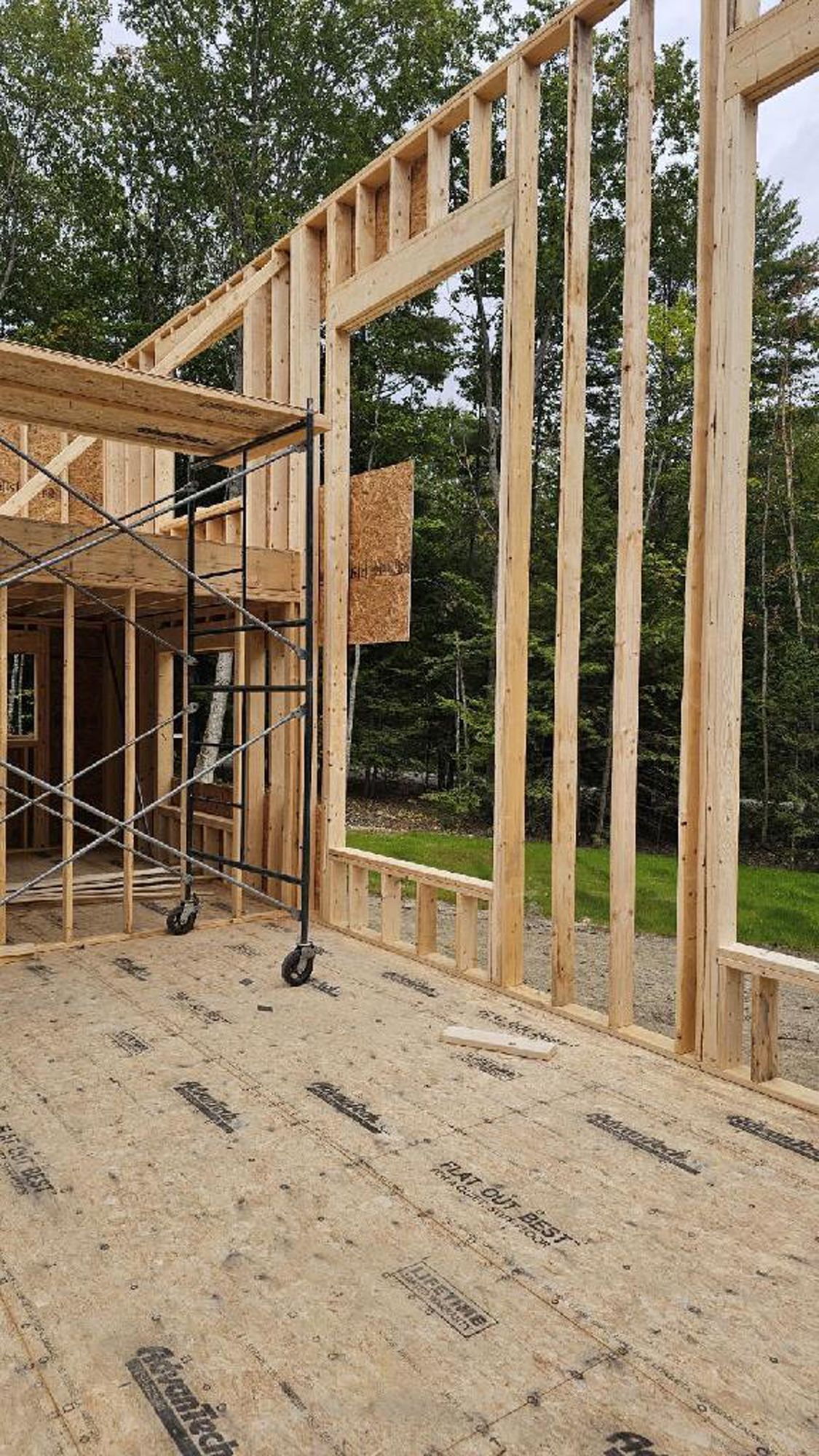 A house is being built with wooden beams and scaffolding.