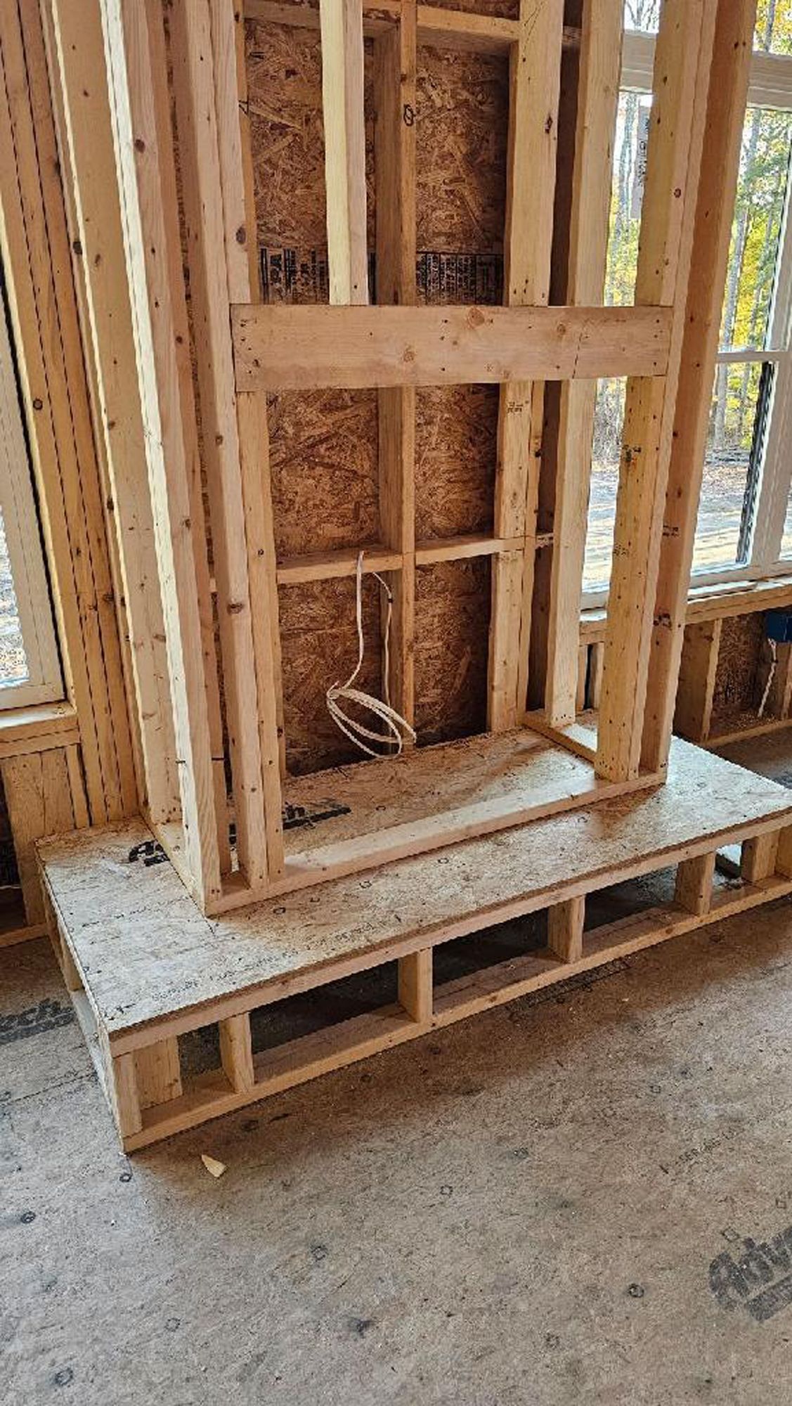 A wooden fireplace is being built in a house under construction.