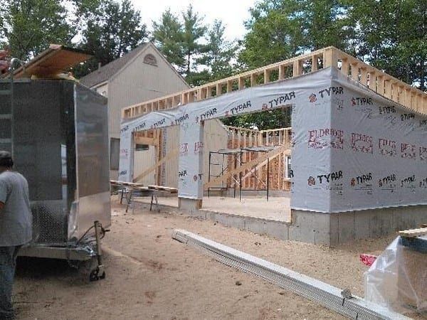 A man is standing in front of a building under construction.