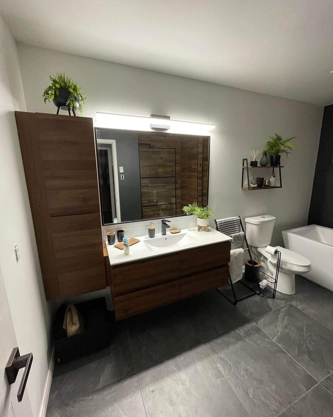 Une salle de bain avec lavabo, WC, baignoire et miroir.