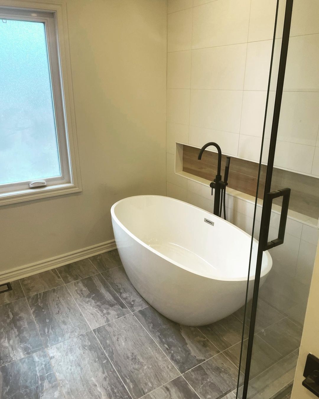 Une salle de bain avec baignoire et fenêtre.