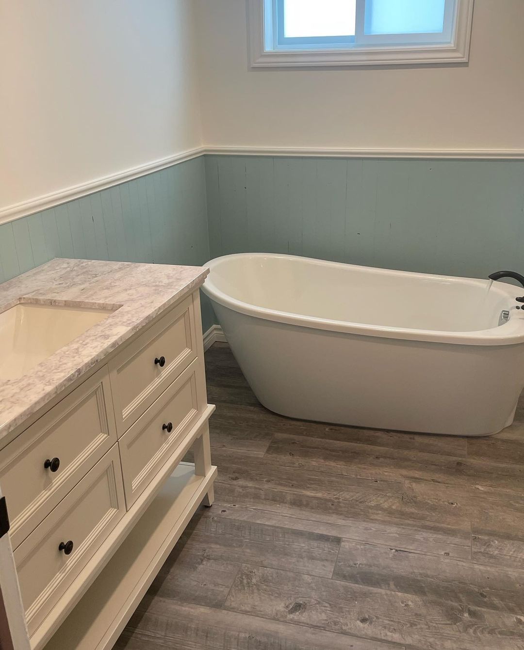 Une salle de bain avec baignoire, lavabo et vanité.