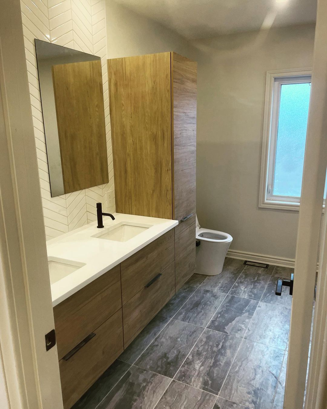 Une salle de bain avec lavabo, WC et miroir.