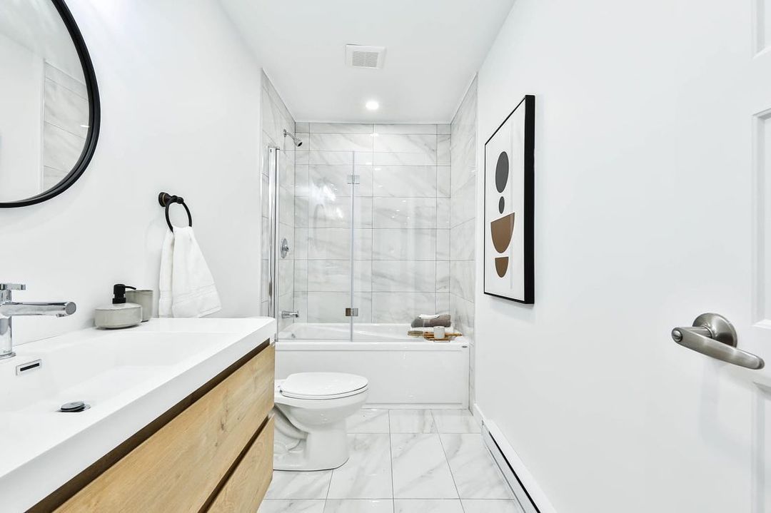 Une salle de bain avec lavabo, WC, baignoire et miroir.